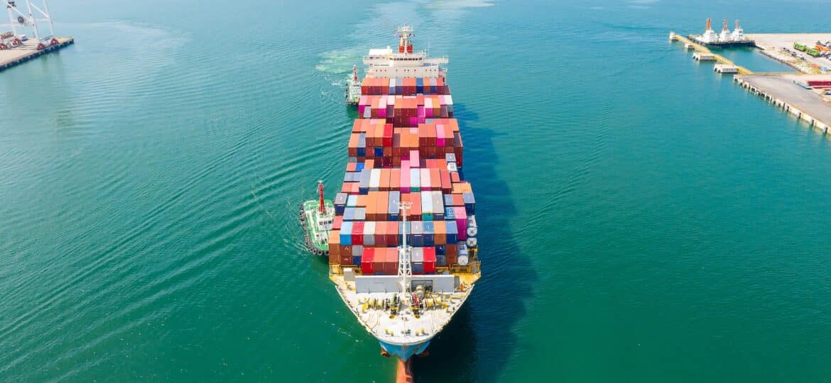 Aerial top view of cargo ship carrying container for import export goods to customer