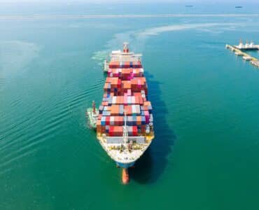 Aerial top view of cargo ship carrying container for import export goods to customer